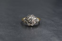 An 18ct gold and diamond daisy cluster ring having a central collared brilliant cut diamond 0.