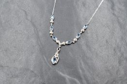 An 18ct white gold aquamarine and diamond set necklace, the six pear cut aquamarines alternating