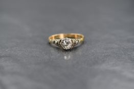 A yellow metal diamond solitaire ring having a 0.25ct stone in a collared mount to raised moulded