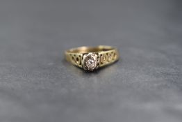 A 9ct gold diamond solitaire ring having a small illusion set diamond to raised butt shoulders on