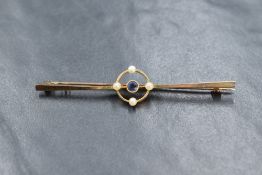 A 15ct gold sapphire and pearl set bar brooch, the central round cut sapphire in an openwork