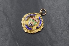 A 9ct gold medallion, for the Cumberland R.L. Cup, having the enamelled crest and name within a