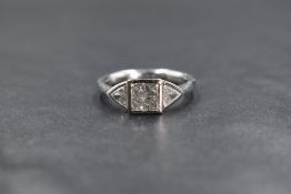 A platinum diamond set three stone ring, the central princess cut diamond measuring approximately
