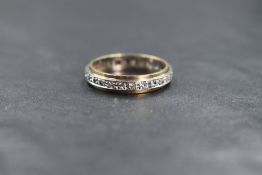 A 9ct gold clear gemstone likely topaz or sapphire set full eternity band, the round cut gemstones