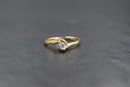 A 9ct gold cubic zirconia set solitaire ring, the round brilliant cut cubic zirconia in a cross over