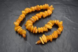 A string of butterscotch amber beads of uneven form having screw clasp, approx 18' & 68.5g
