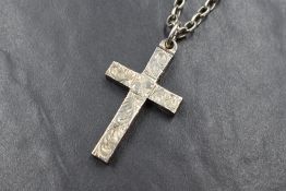 A solid silver cross pendant, having decorative scroll engraving to the front, having sterling