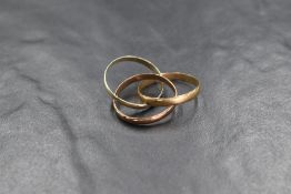 A 9ct gold three tone trinity ring, having interlocking yellow, rose and white gold bands, marked