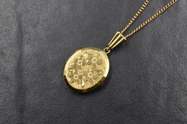 A small gold plated locket having engraved floral decoration on a 20' fine curb link chain stamped