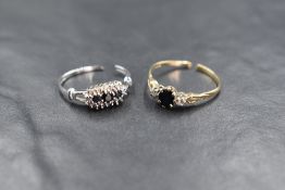 A 9ct gold sapphire and diamond set three stone ring, the central oval cut sapphire flanked by two