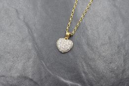 An 18ct gold diamond encrusted heart pendant having thirty five small pave set diamonds totalling