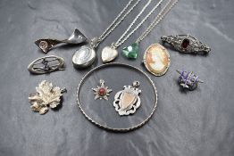 A small selection of silver & white metal jewellery including a bangle, brooches, pendants,