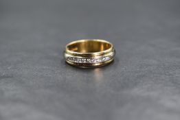 An 18ct gold two tone diamond set band, the central raised band set with nine round brilliant cut