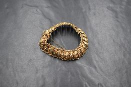 A 9ct gold fancy link bracelet, the foliate motif links having a curb style link border, marked