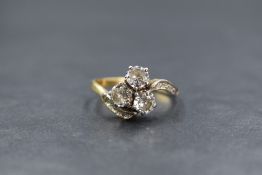 A yellow metal presumed gold diamond set trefoil ring, the three round brilliant cut diamonds