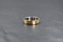 An 18ct gold two tone band, the white gold band having a yellow gold channel decoration, marked 750,