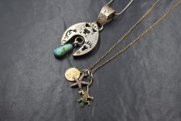 A small 9ct gold St Christopher pendant on a yellow metal chain with a silver star fish charm and