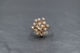 A 9ct gold modern diamond set cluster ring, the sixteen round brilliant cut diamonds in a modern