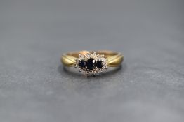 A 9ct gold sapphire and diamond set cluster ring, the three graduated sapphires in a diamond chip