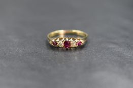 A yellow metal ruby & diamond ring having three small graduated rubies interspersed by two old cut