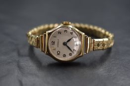 A ladies vintage 9ct gold wrist watch by Visible having an Arabic numeral dial to white face in a