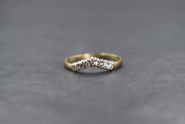 A 9ct gold cubic zirconia set wishbone ring, the seven round cut cubic zirconia in a wishbone