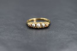 An 18ct gold seed pearl ring having five graduated small split seed pearls in a gallery mount on a