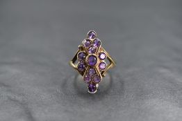 A 9ct gold amethyst set plaque ring, the central round cut amethyst in a twelve round cut amethyst
