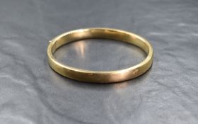 A 9ct gold hinged bangle of plain hollow form having concealed clasp, inner diameter 62mm x 53mm &