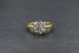 An 18ct gold daisy cluster ring, having seven brilliant cut diamonds, approx 0.85ct total in a