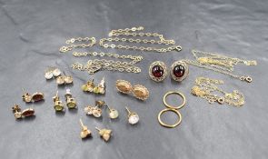 An assortment of 9ct gold and yellow metal jewellery, including fine neck chains, hoop earrings