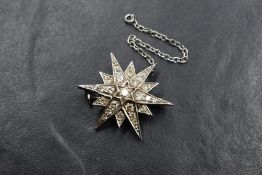 An 18ct white gold diamond set star brooch, having twenty-five round brilliant cut diamonds,