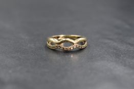 A 9ct gold diamond chip set band, the openwork infinity band having diamond chips set to one side,