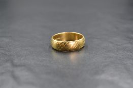 An 18ct gold wedding band having cut stripe detail, size S/T & approx 7.5g