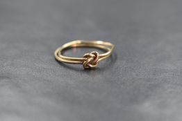 A minimal 9ct gold knot ring, the two gold wires in a decorative knot, marked 9c, ring size N-O, 1.