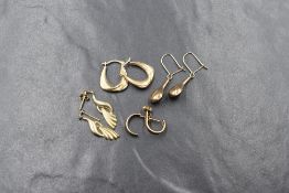 Four pairs of yellow metal earrings for pierced ears, all of different designs and probably 9ct