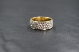 An 18ct gold four row diamond set band ring having seventy eight small pave set brilliant cut