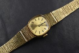 A ladies vintage 9ct gold wrist watch by Tissot having a baton numeral dial to gold coloured face in