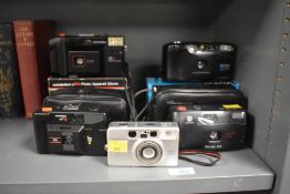 A collection of five compact film cameras. A Vivitar EZ200 35mm film camera, a Hanimex 35hs 35mm