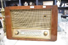 A mid 20th-century HMV Model 1251 valve radio, having a veneered wood cabinet, gilded trim and a '