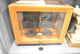 A 20th-century brass Chemical Balance, housed in a wooden and glass case, 46cm.