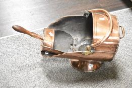 A large Victorian copper coal helmet with a turned wood handled coal scoop, unmarked, (2), condition
