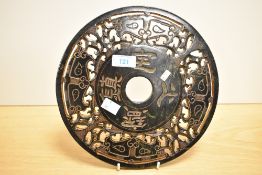 A decorative Chinese carved and pierced black stone Bi/Yubi type disc/carving, of circular form with