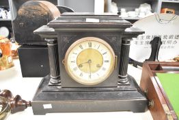 A 19th-century black 8-day mantel clock, having black Roman numerals on an enamelled chapter ring,