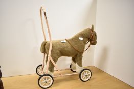 A early to mid 20th-century push-along horse toy, featuring a sweet plush-covered light brown