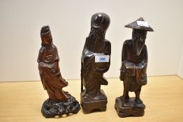Three 20th-century Chinese carved hardwood figures, most likely of immortals, each dressed in