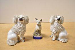 A pair of Victorian Staffordshire “gravelware” mantel poodles, their hindquarters smooth and