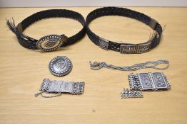 A woven belt, silver tone chain, buckles and cuffs bearing Eastern lettering, needs repair.