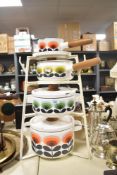 A set of contemporary Orla Kiely enamel casserole pans and milk pans with acacia handles,