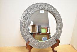 A 20th-century Arts and Crafts KSIA-style embossed pewter mounted oval mirror, featuring a